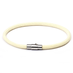 Minimalist cream braided cord bracelet with silver magnetic clasp on white background