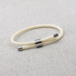 Detailed macro view of cream braided rope bracelet with adjustable silver metal slide buckle