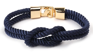 Détail d'un bracelet en corde nautique bleu marine avec un fermoir doré classique