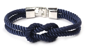 Détail d'un bracelet nautique bleu marine avec fermoir poli en forme de nœud argenté