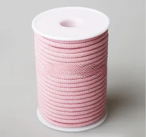 Detailed macro view of pink braided cord spool for DIY jewelry making and crafts