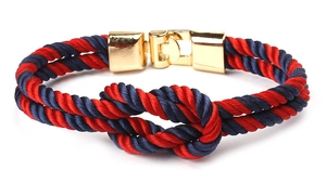 Detail of red and blue braided nautical bracelet with polished gold metal buckle
