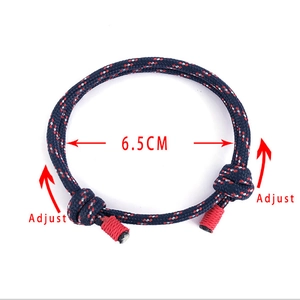 Detail of adjustable blue paracord bracelet with red accents and size marker