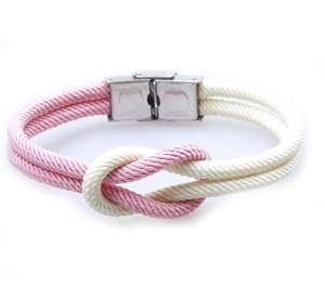 Detail of pink and beige woven rope bracelet with sailor knot and stainless steel clasp