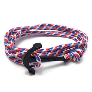 Detail of nautical anchor clasp with VIKINGS engraving on tricolor braided rope bracelet