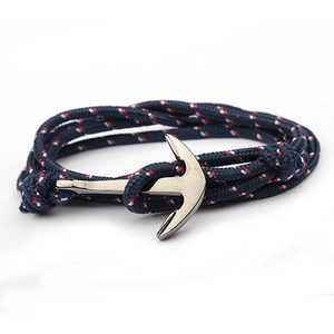 Detail of navy nylon rope bracelet featuring a polished silver metal anchor clasp