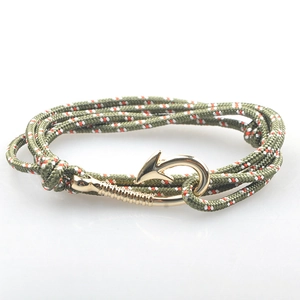 Dettaglio del bracciale nautico intrecciato verde militare con chiusura ad ancora dorata