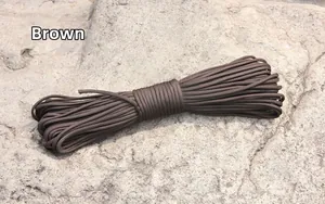 Brown 7-strand paracord bundled on a rugged rock background for outdoor camping use