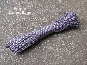 Detail of purple camouflage 4mm paracord roll on outdoor gravel ground surface