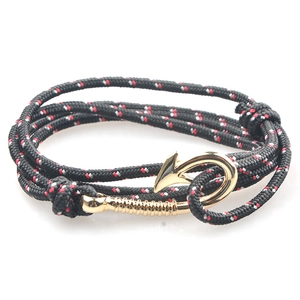 Dettaglio della chiusura a amo dorata sul bracciale nautico in paracord nero e rosso