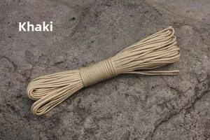 Detail of khaki 4mm 7-strand paracord rope placed on natural grey rock for camping