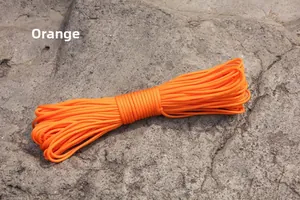 Detail of high-strength orange paracord on a grey rock for outdoor camping use