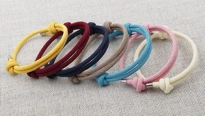 Detailansicht bunter Nylonarmbänder mit Segelknoten und hochwertigen Metallkappen
