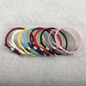 Détail de bracelets en nylon tressé multicolores avec perles réglables en acier