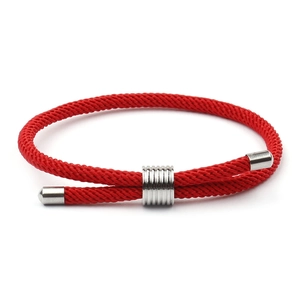 Gros plan du bracelet en corde rouge tressée réglable avec fermoir coulissant en métal argenté