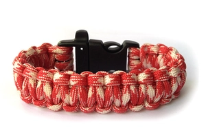 Close-up of red and beige paracord survival bracelet with a black quick-release buckle