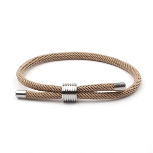 Vue détaillée du bracelet en nylon tressé kaki avec un charme cylindrique en métal argenté