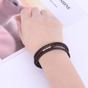 Dettaglio del bracciale multistrato in pelle intrecciata marrone scuro con chiusura argento