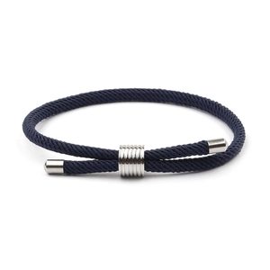 Gros plan détaillé du bracelet tressé bleu foncé avec éléments en acier inoxydable poli