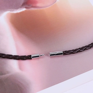 Dettaglio di un bracciale in pelle PU intrecciata marrone scuro con chiusura a incastro argento