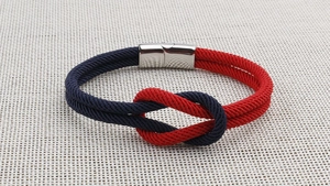 Nahaufnahme vom rot-blauen geflochtenen Armband mit poliertem Magnetverschluss aus Stahl