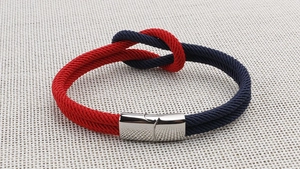 Detail eines rot-blau geflochtenen Segelseil-Armbands mit Edelstahl-Verschluss
