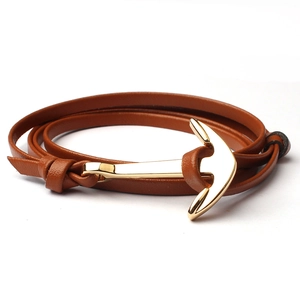 Close-up of brown leather double-wrap bracelet with a gold metal anchor shackle clasp