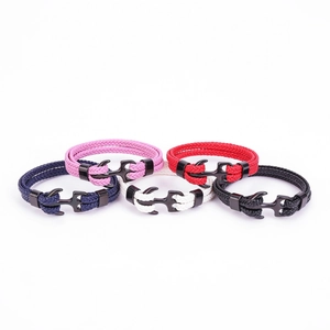 Close-up of anchor-shaped metal clasps on woven nautical bracelets in five vibrant colors