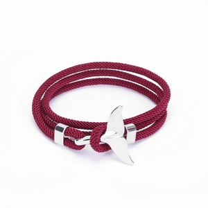 Dettaglio del bracciale intrecciato rosso scuro con chiusura a forma di coda di balena
