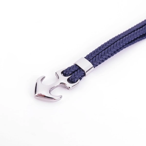 Macro shot of polished silver anchor clasp with nautical deep blue braided fiber rope