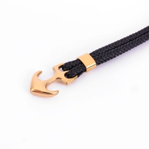 Men's nautical black braided leather bracelet with a polished gold anchor clasp