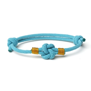 Adjustable light blue woven couple bracelet with gold thread accents and knots