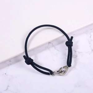 Close-up of adjustable navy braided rope bracelet with a silver stainless steel handcuff clasp