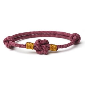 Handcrafted pink braided couple bracelet with golden thread accents and center knot