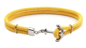Détail d'un bracelet en corde de nylon jaune avec un fermoir ancre en argent poli