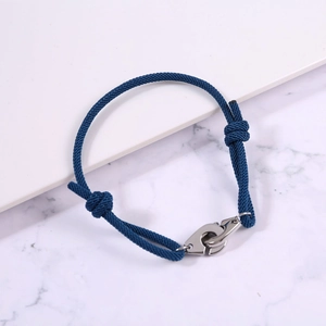Close-up of blue braided rope bracelet with silver handcuffs buckle and adjustable knots