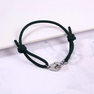 Detail of adjustable dark green braided rope bracelet with silver handcuff clasp closure