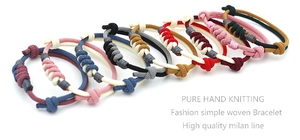 Detail showing various colors of hand-knitted cord bracelets with minimalist knots