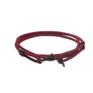 Dettaglio del braccialetto in corda intrecciata rossa con fibbia a forma di delfino