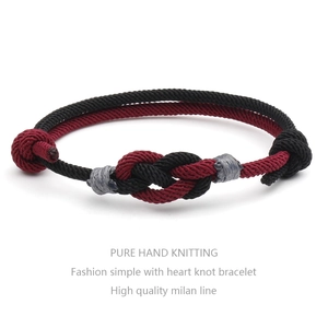 Detailed view of hand-woven red and black couple bracelets with concentric heart knot
