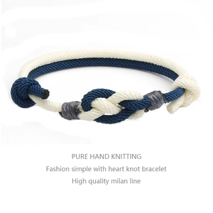 Close-up of hand-woven heart knot bracelets in blue and beige milan cord