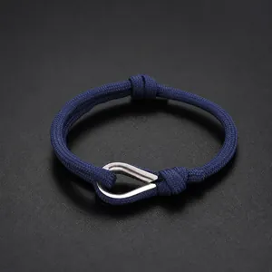 Detail view of navy blue braided rope bracelet with a polished silver teardrop metal clasp