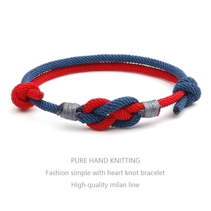 Detailed macro view of handcrafted red and blue woven knots on a couple's bracelet