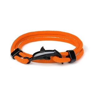 Dettaglio di un bracciale intrecciato arancione a tre giri con chiusura nera a delfino