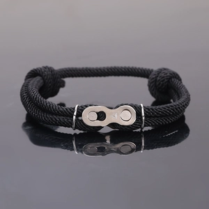 Détail d'un bracelet en corde tressée noire avec boucle de chaîne en acier inoxydable