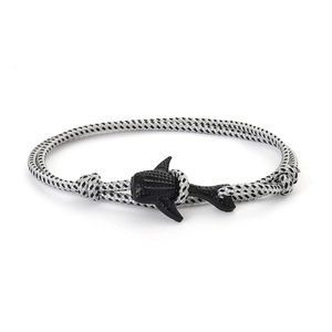 Détail d'un bracelet en corde tressée avec fermoir en forme de requin noir sur blanc