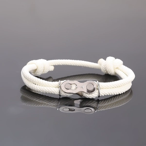 Gros plan d'un bracelet en corde tressée blanche avec maillon de chaîne de style industriel