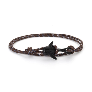 Détail macro du bracelet nautique tressé avec fermoir en forme de requin noir mat élégant