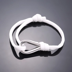 Detail of white braided rope bracelet with polished stainless steel U-shaped metal clasp