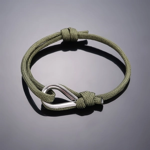 Close-up of olive green braided paracord bracelet with polished silver metal U-shackle